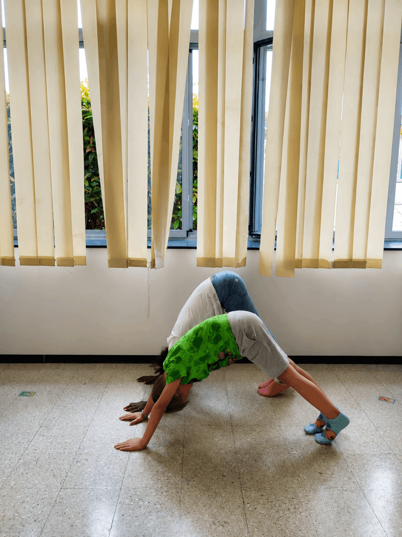 Enfant pratiquant la posture du chien tête en bas lors d’une séance de yoga à Agde